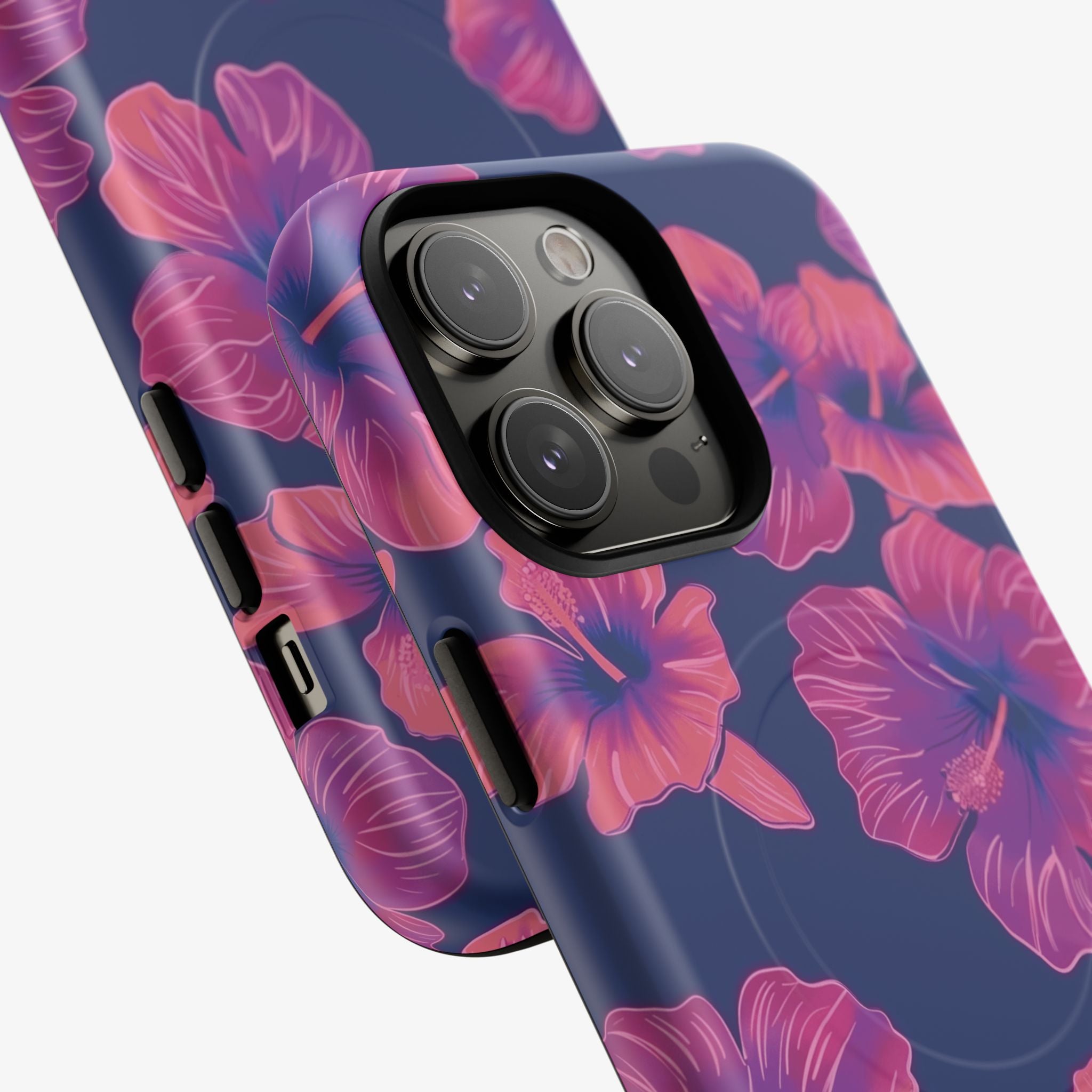 Close-up of a phone with a Maui Mood | Signature Series Phone Case (MagSafe) featuring a navy blue background and vibrant pink floral design, showing camera and button cutouts.
